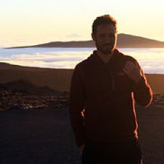 a man standing next to a body of water