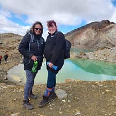 a group of people standing on a rocky beach