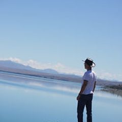 a man standing on a rock next to water