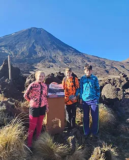 a group of people standing in front of a mountain